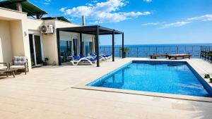 a swimming pool on a patio with a view of the ocean at Private Sea View with Infinity Pool in VILLA NERIN Zagora in Zagora