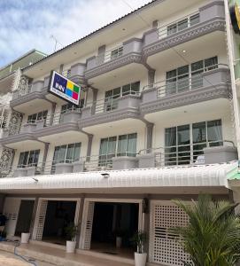 a large white building with a sign on it at THE BEACH INN Cha-Am in Cha Am