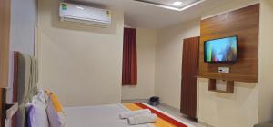 a room with a bed and a tv on a wall at Hotel Sunrise View in Ahmedabad +31 photos