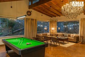 a living room with a pool table at StayVista at The Cloudberry Crest with BBQ & Bonfire in Rāmgarh