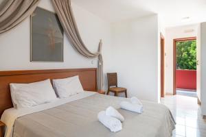 a bedroom with a bed with two towels on it at Hotel Aristotelis in Ancient Epidauros