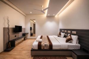 ein Schlafzimmer mit Bett und Flachbildfernseher in der Unterkunft Hotel Gold Star in Rajkot