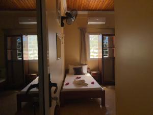 una camera da letto con un letto e due finestre di Bel Hotel Nosy Be a Hell-Ville