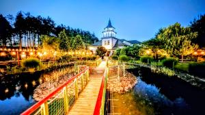 a lighthouse with a bridge in front of a building at Resort Pod Lasem in Kolonowskie