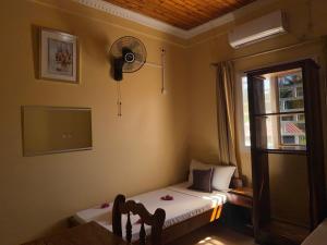 una piccola stanza con un letto e una finestra di Bel Hotel Nosy Be a Hell-Ville