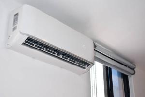 a white air conditioner on top of a window at appartement 65m in Châtillon +9 photos