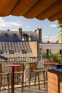 a patio with tables and chairs on a roof at Drawing Hotel in Paris