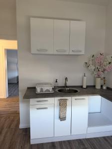 a kitchen with white cabinets and a sink at Apartment Rotenburg in Rotenburg an der Fulda