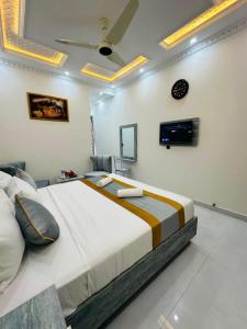 a bedroom with a large bed and a tv on the wall at Go 001 Hotel Lahore in Lahore