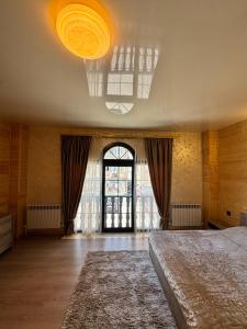 a bedroom with a large bed and a large window at Family House in Sevan