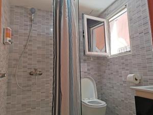 a bathroom with a toilet and a shower with a window at Seaside Oasis at Playa Los Coralles in Punta Cana