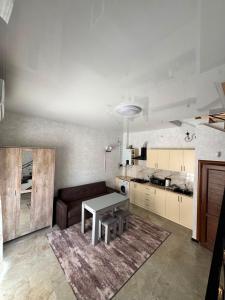 a living room with a table and a kitchen at Family House in Sevan
