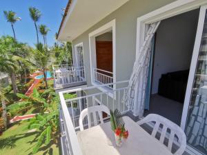 a balcony of a house with a table and chairs at Seaside Oasis at Playa Los Coralles in Punta Cana