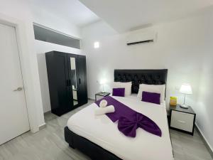 a bedroom with two beds with purple pillows at Seaside Oasis at Playa Los Coralles in Punta Cana +58 photos