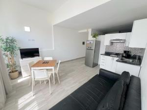 a living room with a couch and a table and a kitchen at Seaside Oasis at Playa Los Coralles in Punta Cana
