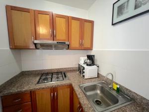 a kitchen with a sink and a stove and a microwave at Seaside Oasis at Playa Los Coralles in Punta Cana