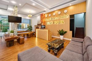 a living room with a couch and a tv at Eluna Lilly Da Lat Hotel in Da Lat