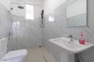 a white bathroom with a sink and a toilet at Why Not Guest House, Ella in Ella