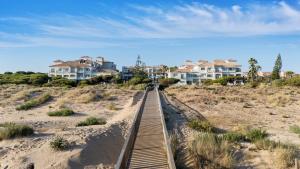 a boardwalk through the sand in front of houses at Barceló Punta Umbría Mar in Punta Umbría