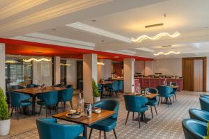 a restaurant with wooden tables and blue chairs at Perfectstayz Prime - 2 min walk to mall road in Mussoorie