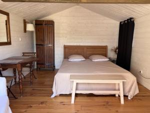 a bedroom with a bed with a table and a desk at Chalet La Bienvenue in Vouzon