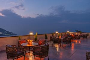 a row of tables and chairs on a patio at night at Perfectstayz Prime - 2 min walk to mall road in Mussoorie