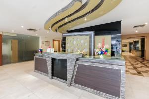 a lobby with a bar in a building at SANS Vibes d Grande Hotel Batam in Nagoya