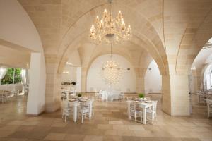 a large room with tables and chairs and a chandelier at Casale del Murgese Country Resort in Savelletri di Fasano