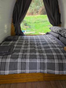 a bed in a room with a window at Doune House Pods in Beauly