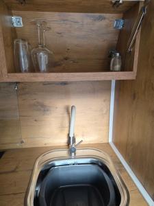 a small bathroom with a sink and wooden walls at Doune House Pods in Beauly +7 photos