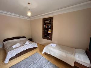 a bedroom with two beds and a book shelf at Qedani in Ch'k'valeri