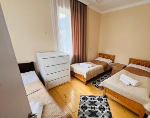 a room with two beds and a dresser in it at Qedani in Ch'k'valeri