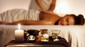 a woman laying on a bed with a table with a candle at Pipa Bangkok Sukhumvit 11 by Kingston Hotels in Bangkok