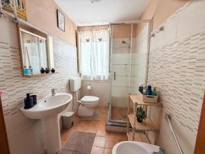 a bathroom with a sink and a toilet and a shower at La casa di Sally in Syracuse