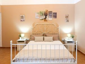 a bedroom with a white bed with two night stands at La casa di Sally in Syracuse