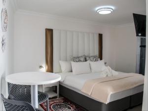 a bedroom with a bed and a white table at Queens Cove in Lüderitz