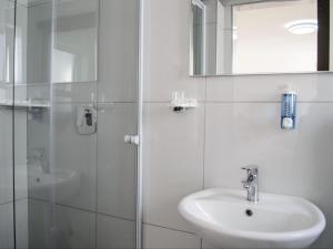 a white bathroom with a sink and a shower at Queens Cove in Lüderitz +32 photos
