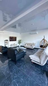 a large living room with couches and a table at Hotel Nena in Kobuleti