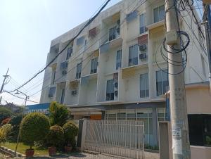an apartment building with a fence in front of it at Townhouse Oak Hotel Damar Kurung in Gresik