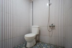 a bathroom with a toilet in a shower stall at Townhouse Oak Hotel Damar Kurung in Gresik