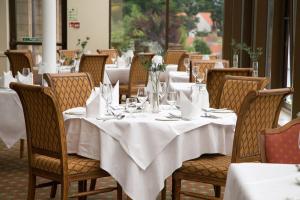a dining room with tables and chairs with white table cloth at Old Manor Hotel in Lundin Links +32 photos