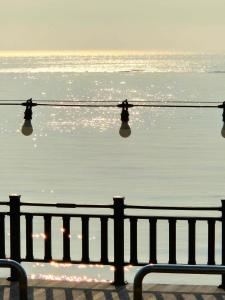 a view of the ocean with a bench and lights at Yeongheungdo Haevichi Pension in Incheon