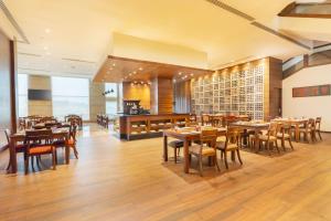 a dining room with wooden tables and chairs at Hyatt Raipur in Raipur