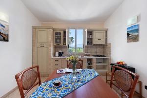 a kitchen with a table and chairs and a kitchen with a counter at Casa Onda Azzurra in Balestrate +17 photos