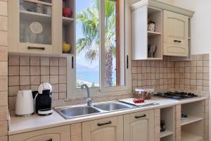 a kitchen with a sink and a window at Casa Onda Azzurra in Balestrate
