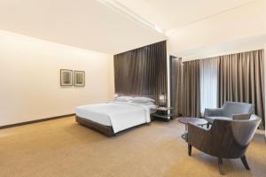 a hotel room with a bed and a chair at Hyatt Raipur in Raipur +27 photos