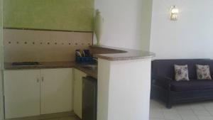 a kitchen with a counter and a blue couch at Résidence PHILA Djerba in Djerba