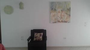 a chair in a room with a picture on the wall at Résidence PHILA Djerba in Djerba