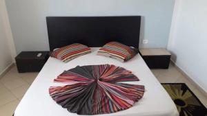 a bed with two pillows on top of it at Résidence PHILA Djerba in Djerba