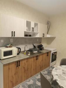 a kitchen with a microwave and a sink at Апартамент Централ in Targovishte
